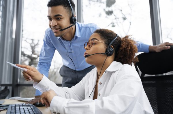 Casal com headphone em uma central de atendimento.